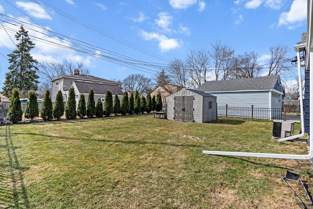 view of yard featuring a fenced backyard, a storage unit, and an outdoor structure