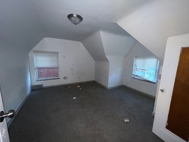 bonus room featuring lofted ceiling, carpet flooring, and baseboards