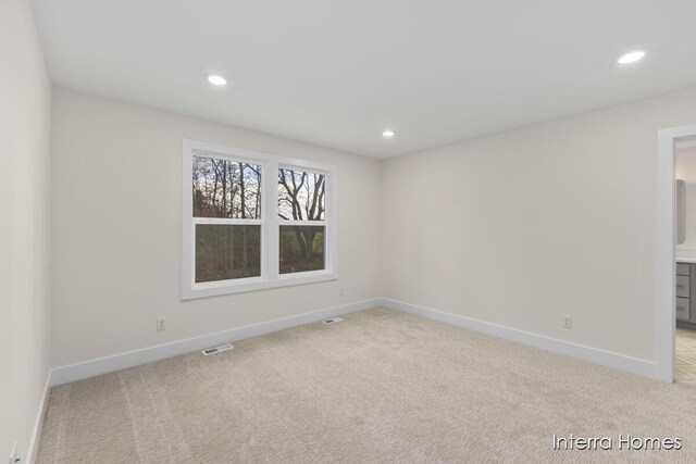 unfurnished room with recessed lighting, light colored carpet, and visible vents