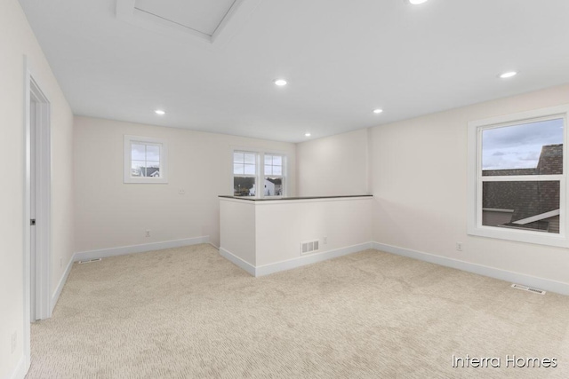 carpeted spare room featuring recessed lighting, visible vents, and baseboards