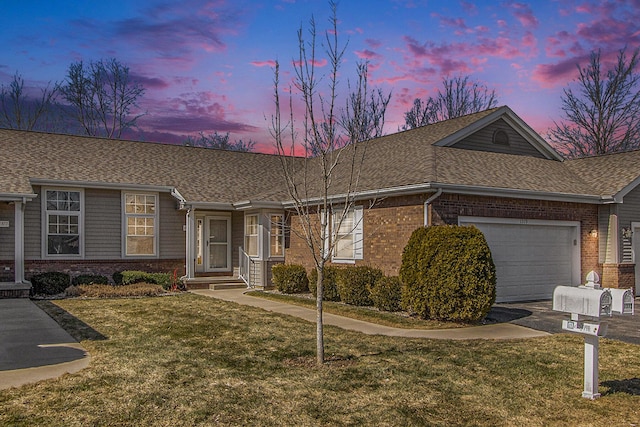 ranch-style house featuring brick siding, a lawn, an attached garage, and a shingled roof