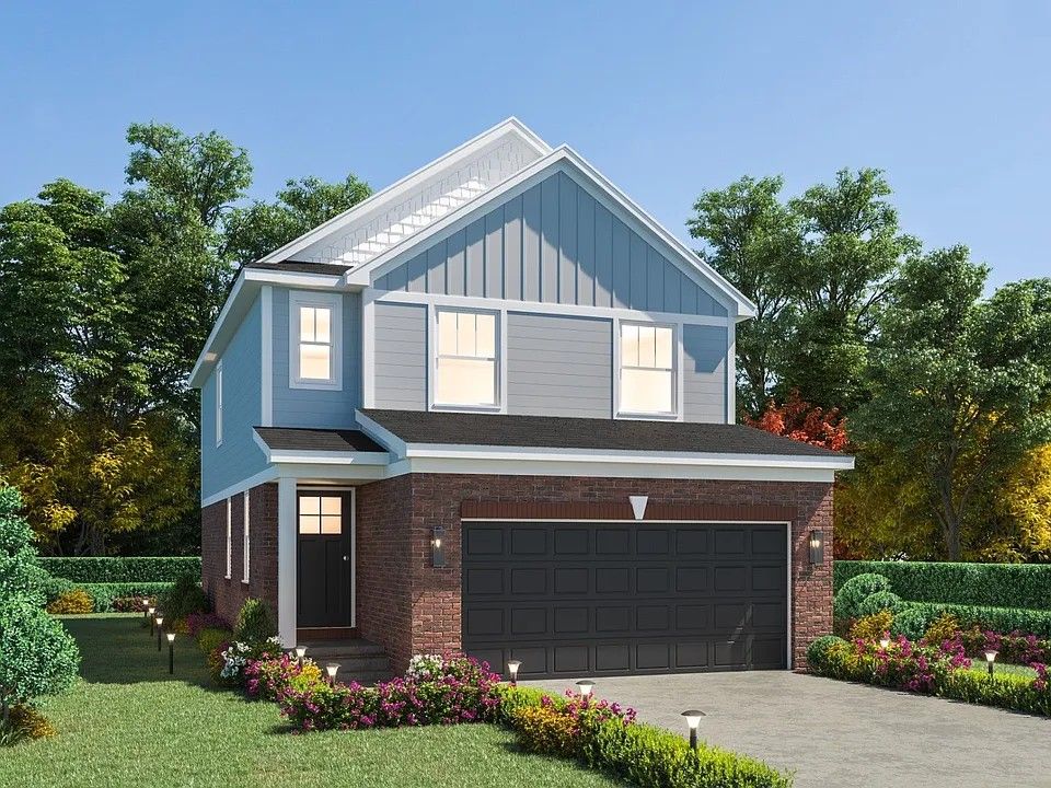 view of front of house with brick siding, board and batten siding, a front yard, a garage, and driveway