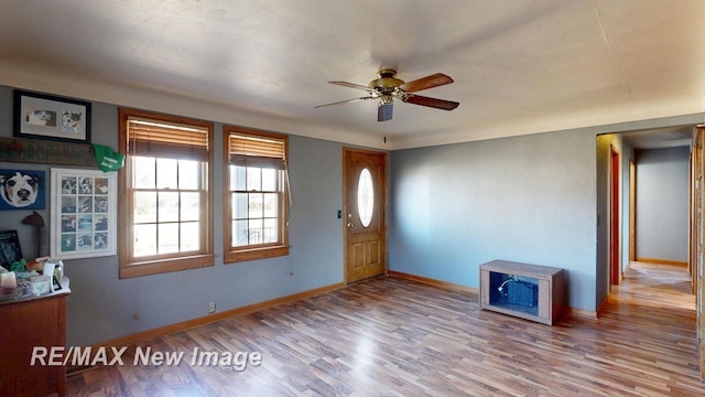 foyer with ceiling fan, baseboards, and wood finished floors