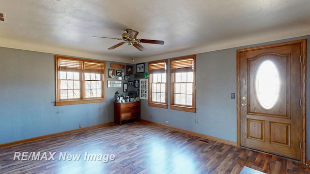 foyer featuring visible vents, wood finished floors, baseboards, and ceiling fan