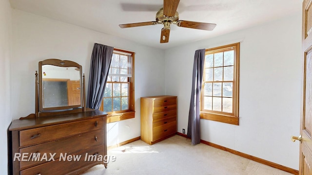 bedroom featuring baseboards, multiple windows, and light colored carpet