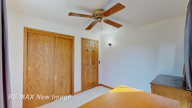 interior space with baseboards, a closet, and ceiling fan