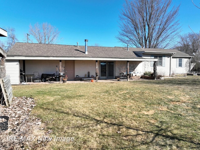 rear view of property with a lawn and a shingled roof