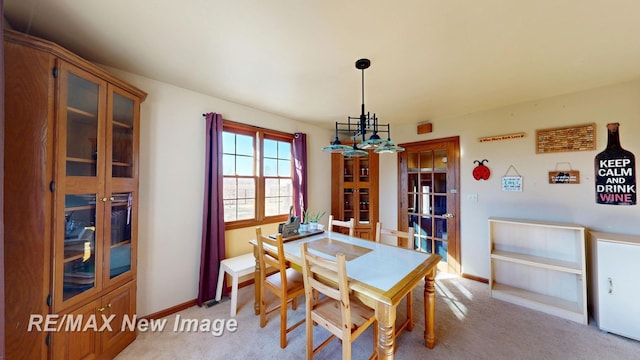 dining room with baseboards and light carpet