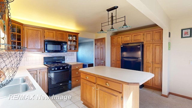 kitchen featuring a sink, tasteful backsplash, black appliances, and light countertops