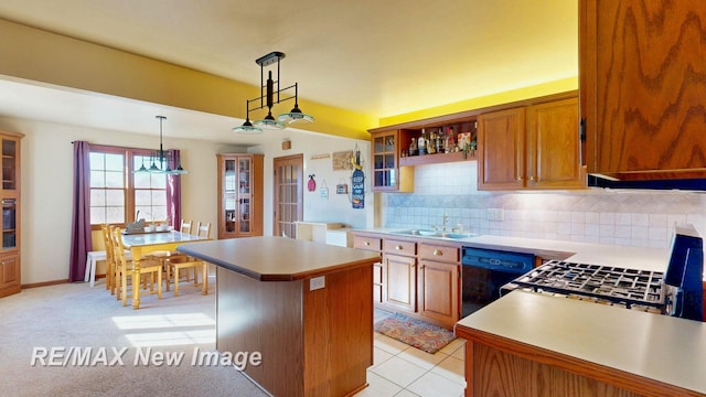 kitchen featuring light countertops, black dishwasher, a kitchen island, and a sink