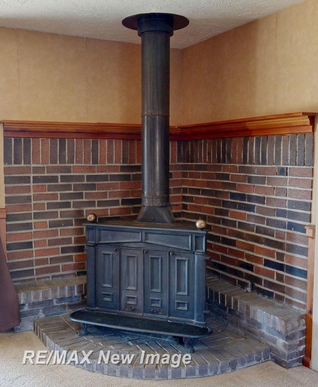 room details featuring carpet, a wood stove, and a textured ceiling