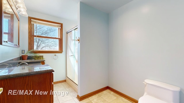 full bath featuring baseboards, toilet, a stall shower, tile patterned floors, and vanity