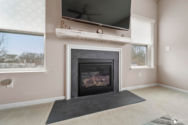 details with a fireplace with flush hearth, carpet, and baseboards