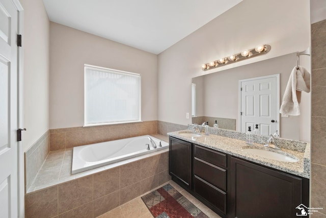 full bathroom featuring a sink, a bath, double vanity, and tile patterned flooring