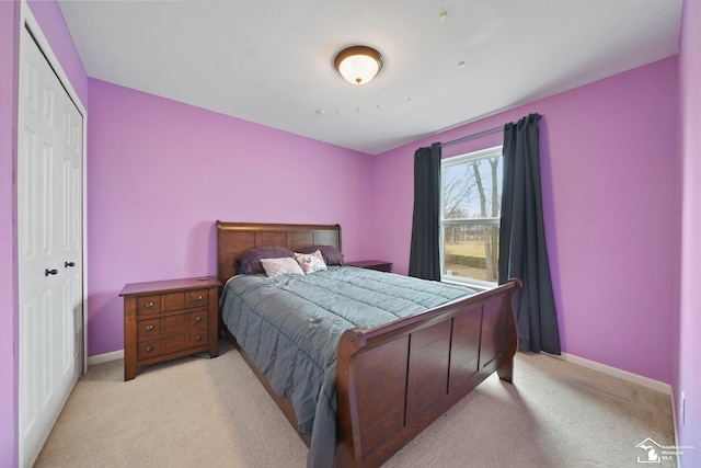 bedroom with light carpet, a closet, and baseboards