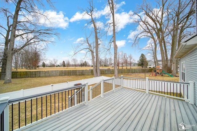 wooden deck featuring a fenced backyard, a playground, and a yard