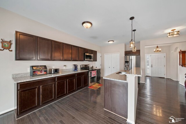 kitchen with dark brown cabinetry, appliances with stainless steel finishes, dark wood-type flooring, and a sink