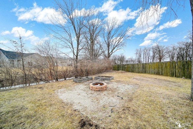 view of yard featuring a fire pit and fence