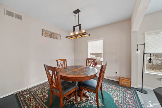 dining room featuring a notable chandelier, visible vents, and baseboards