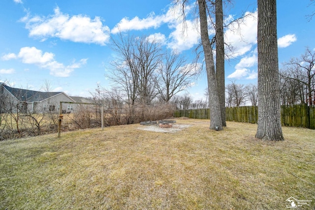 view of yard with fence and an outdoor fire pit