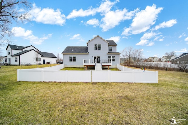 rear view of house with a yard, a residential view, a wooden deck, and a fenced backyard