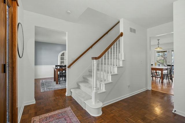 staircase with visible vents and baseboards