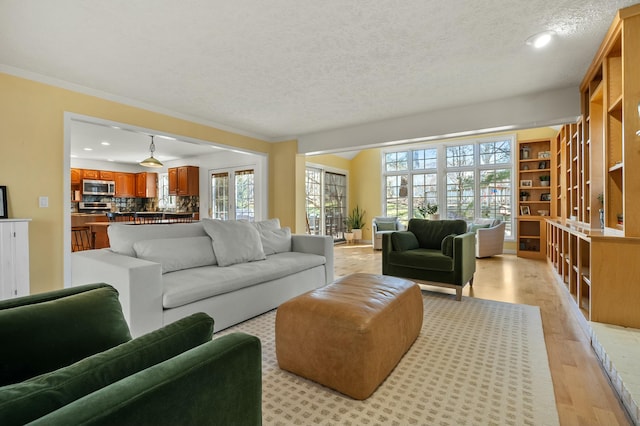 living room with light wood finished floors, recessed lighting, a textured ceiling, and crown molding