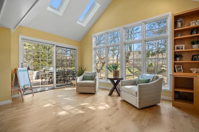 sitting room featuring high vaulted ceiling, a skylight, baseboards, and wood finished floors