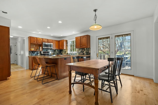 dining area featuring recessed lighting, light wood-type flooring, and baseboards