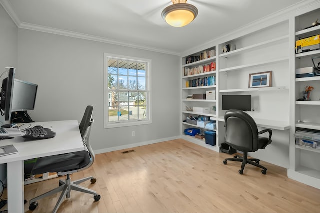 office space with light wood finished floors, visible vents, baseboards, built in features, and ornamental molding