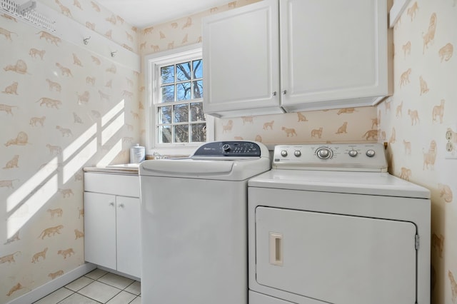 washroom with cabinet space, washer and clothes dryer, and wallpapered walls