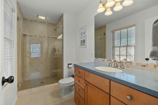 bathroom with tile patterned floors, vanity, toilet, and a shower stall