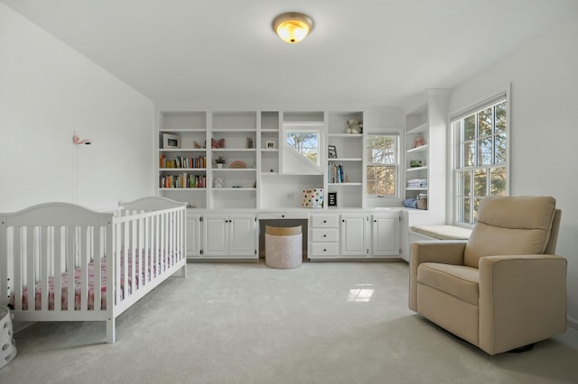 bedroom featuring a nursery area and light carpet