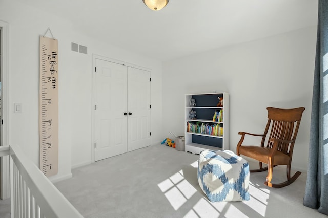 living area featuring visible vents and carpet floors