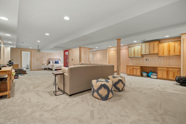 living area with recessed lighting, light colored carpet, and wooden walls