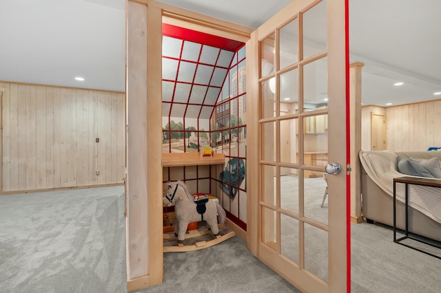 interior space with carpet flooring, recessed lighting, and wooden walls