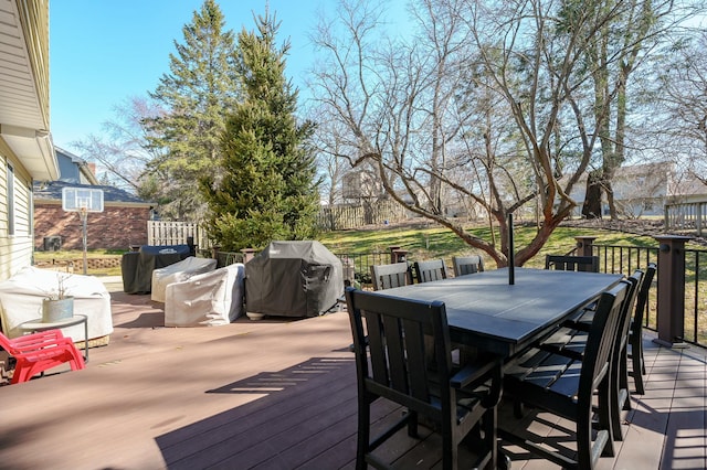 deck featuring outdoor dining space, a grill, and fence