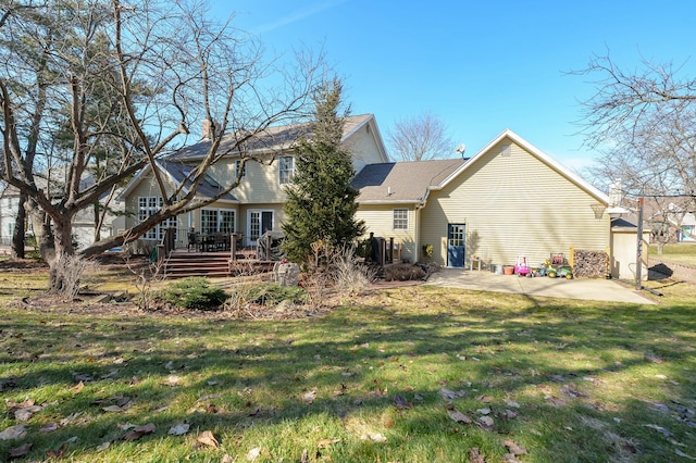 rear view of property with a yard, a deck, and a patio area