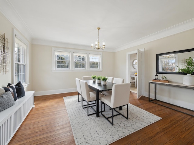 dining area with baseboards, an inviting chandelier, hardwood / wood-style floors, and crown molding