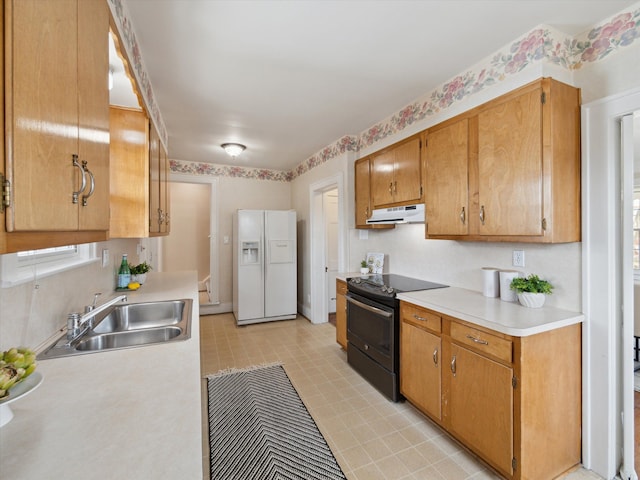 kitchen with black range with electric stovetop, a sink, under cabinet range hood, white fridge with ice dispenser, and light countertops