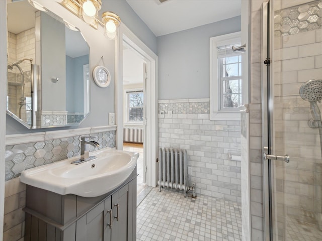 bathroom featuring tile walls, radiator heating unit, and plenty of natural light