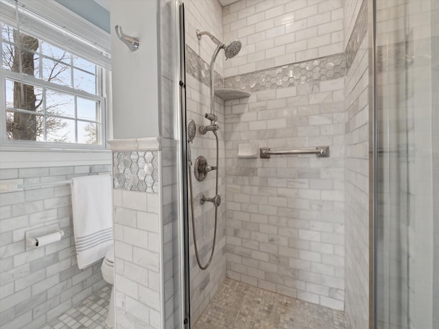 full bath featuring a wainscoted wall, toilet, and a stall shower