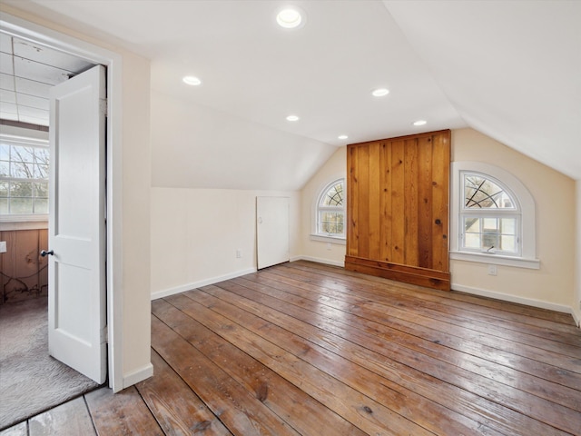 bonus room with baseboards, lofted ceiling, and hardwood / wood-style floors