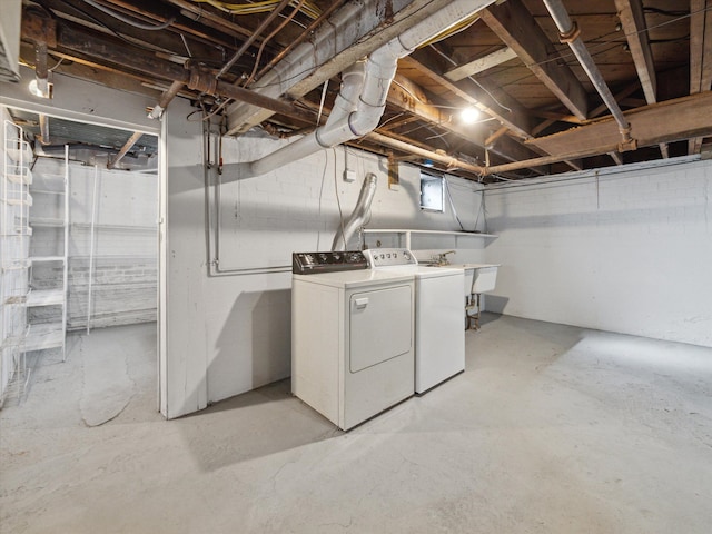 below grade area featuring a sink and washing machine and clothes dryer