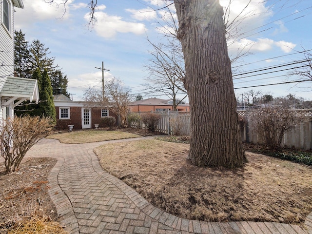 view of yard featuring an outdoor structure and fence