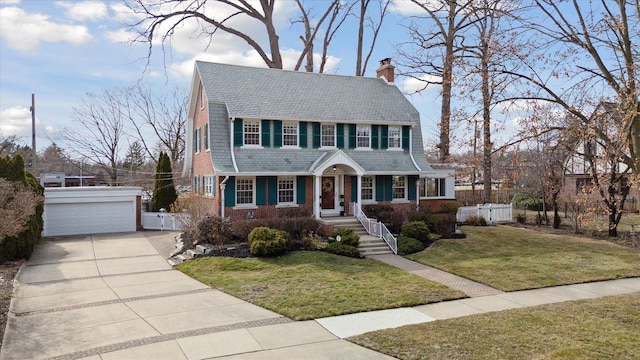 view of front of property featuring a gambrel roof, a front lawn, fence, an outdoor structure, and brick siding