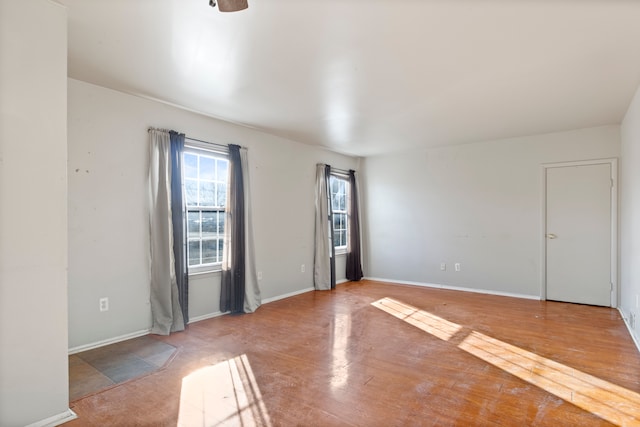 unfurnished room with baseboards and wood finished floors