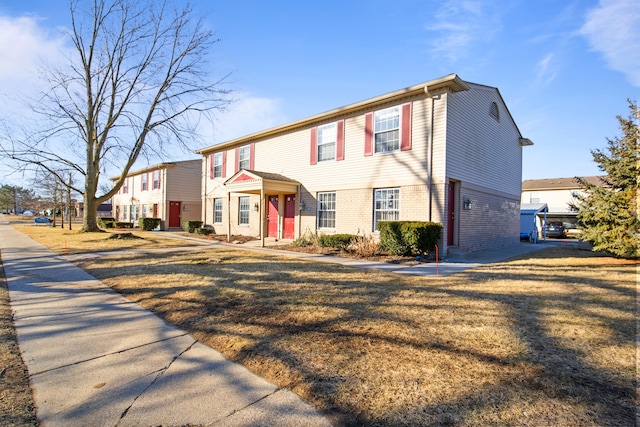 view of front of property with brick siding, a residential view, and a front yard