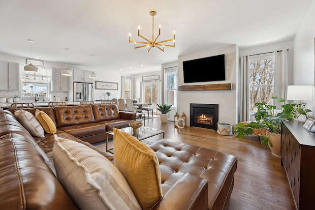 living room with recessed lighting, a fireplace, an inviting chandelier, and wood finished floors