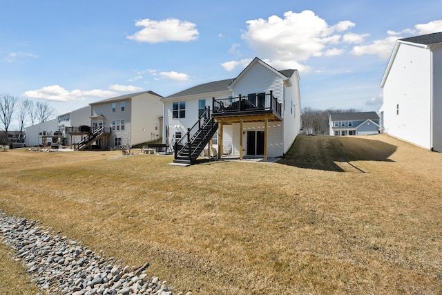 rear view of house featuring a residential view, a lawn, a wooden deck, and stairs